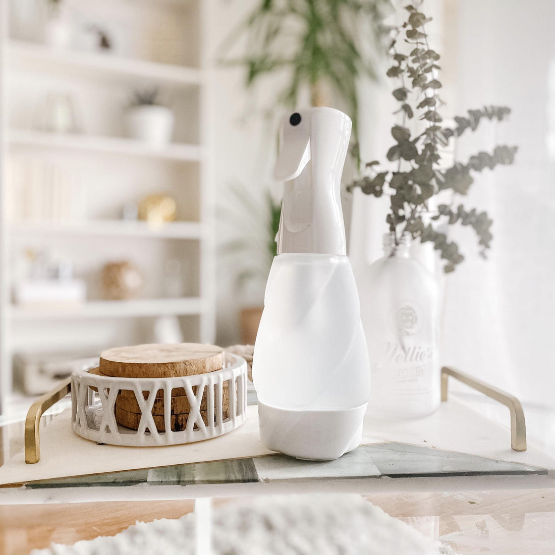 Frosted glass reusable spray bottle on coffee table